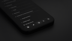 Close-up of a smartphone showing the Linear app interface, with a blurred list of projects and navigation icons along the bottom.